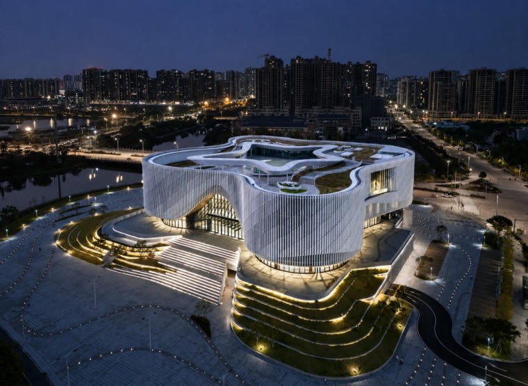 Night aerial view of Yangjiang Cultural Center with illuminated white terracotta fins Night aerial view of Yangjiang Cultural Center with illuminated white terracotta fins
